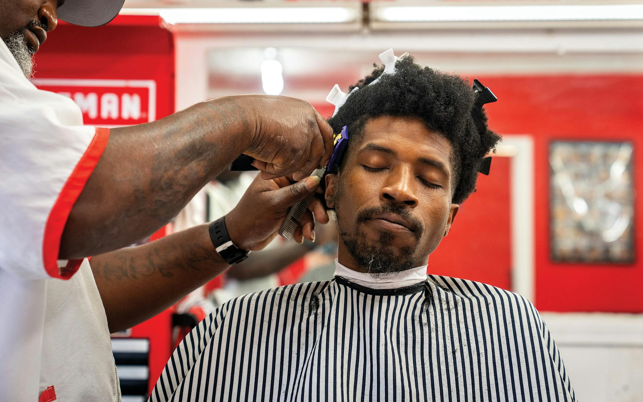 May 10 2:23 P.M. Dominique Dixson getting his hair cut by Mike McMahon at a barber shop a mile east of the Dallas Zoo.