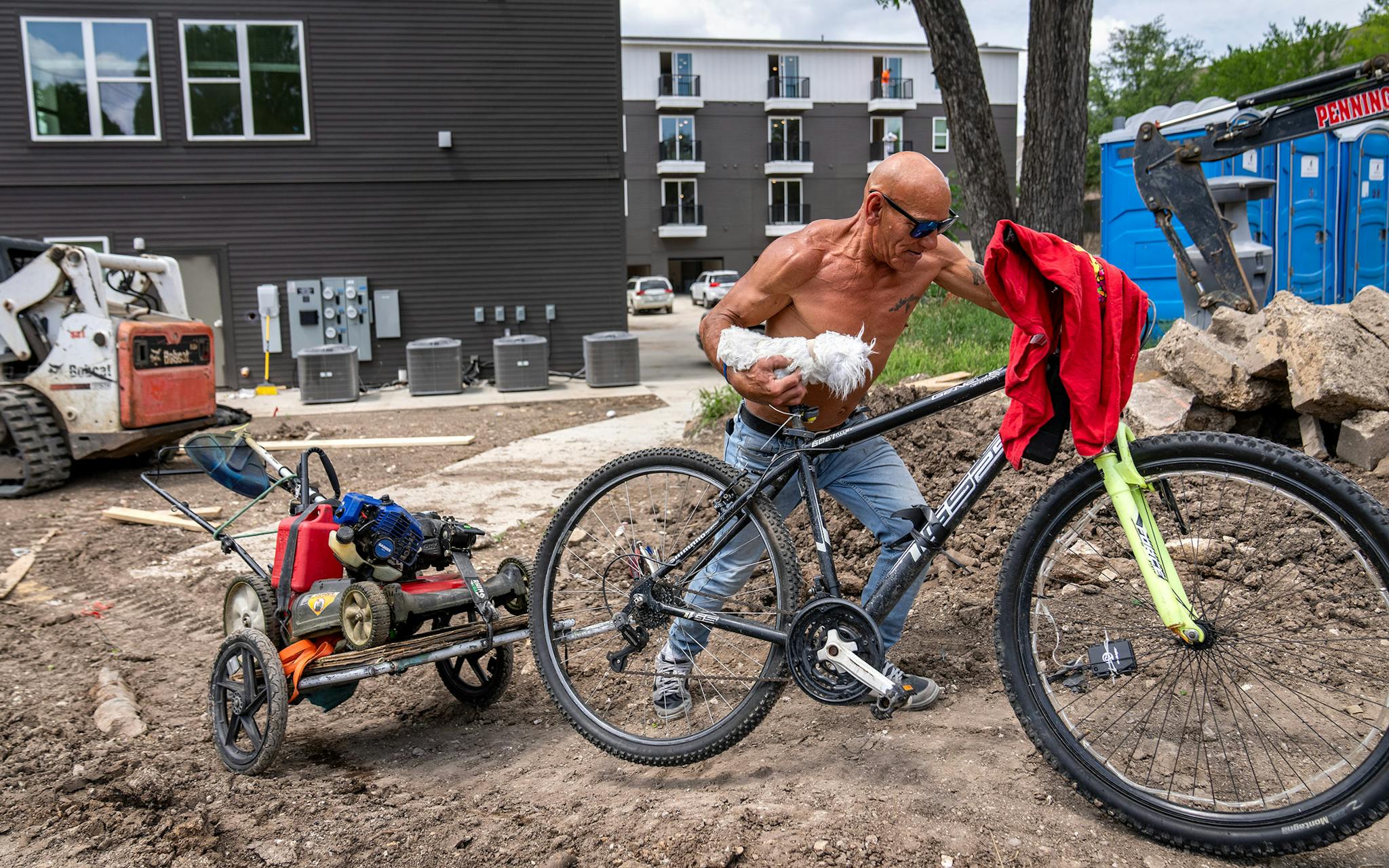May 10 2:39 P.M. Robert Villareal, 56, pushes his bicycle, with lawn mower and string trimmer in tow, through a construction site just east of the Dallas Zoo. Villareal, who grew up in Oak Cliff and went to Adamson High School, said he was on his way to cut a friend’s grass “to make some extra money.” “It’s just a regular Briggs & Stratton,” he said of his lawn mower, “It’s nothing fancy, just something to get the job done.”