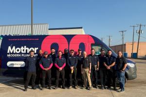 Mother Modern Plumbing staff stands in front of service van at new Plano, TX location.