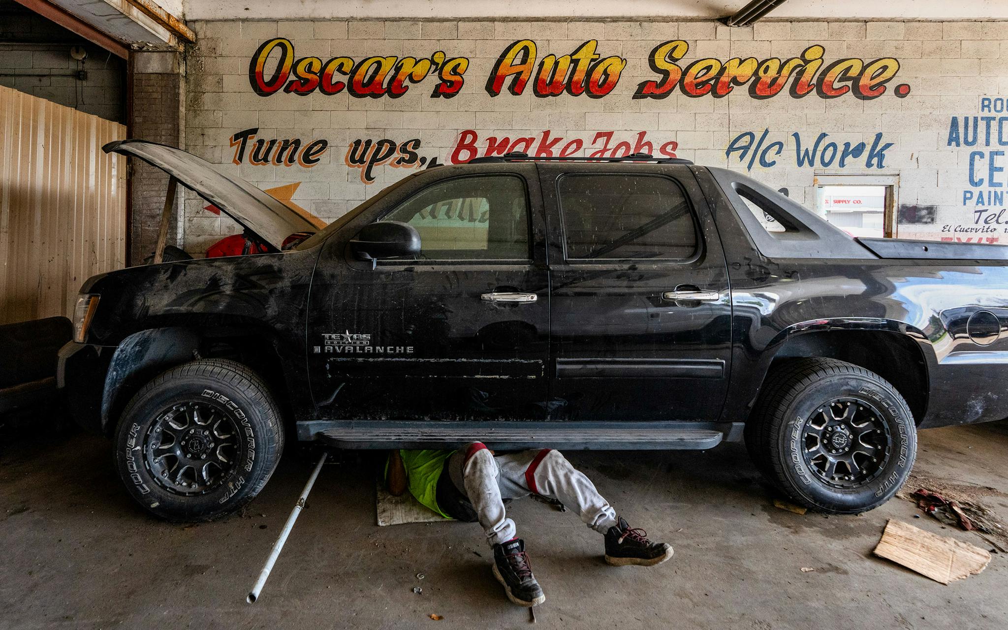 May 10 3:46 P.M. Fernando Martinez, 22, works under a Chevrolet Avalanche at Oscar’s Auto Service on North Marsalis Avenue.