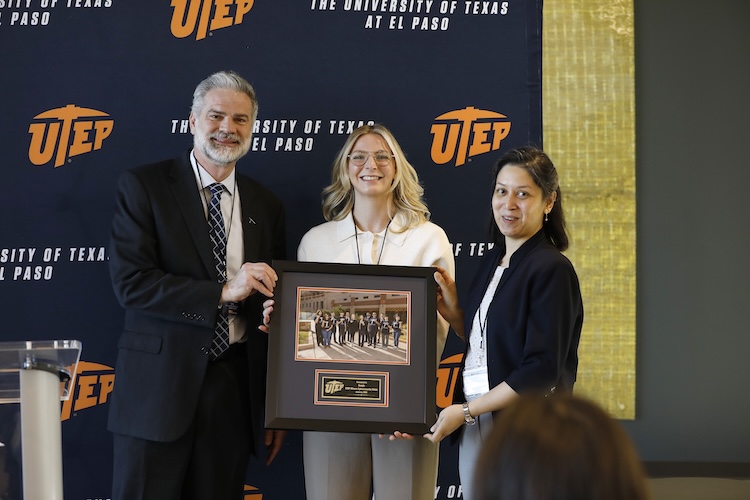 John Wiebe, Ph.D. (left), UTEP provost and vice president for academic affairs, and Monika Akbar, Ph.D. (right), faculty lead and director of the Miners Cybersecurity Clinic, presented a framed photo of the clinic’s inaugural cohort to Paige Godvin (center), a security consultant for Google, during a press conference on Jan. 30, 2026, on the UTEP campus to celebrate the completion of the clinic’s first full operational cycle. The Miners Cybersecurity Clinic was established in 2024 through $1 million in funding from Google’s Cybersecurity Clinics Fund.
