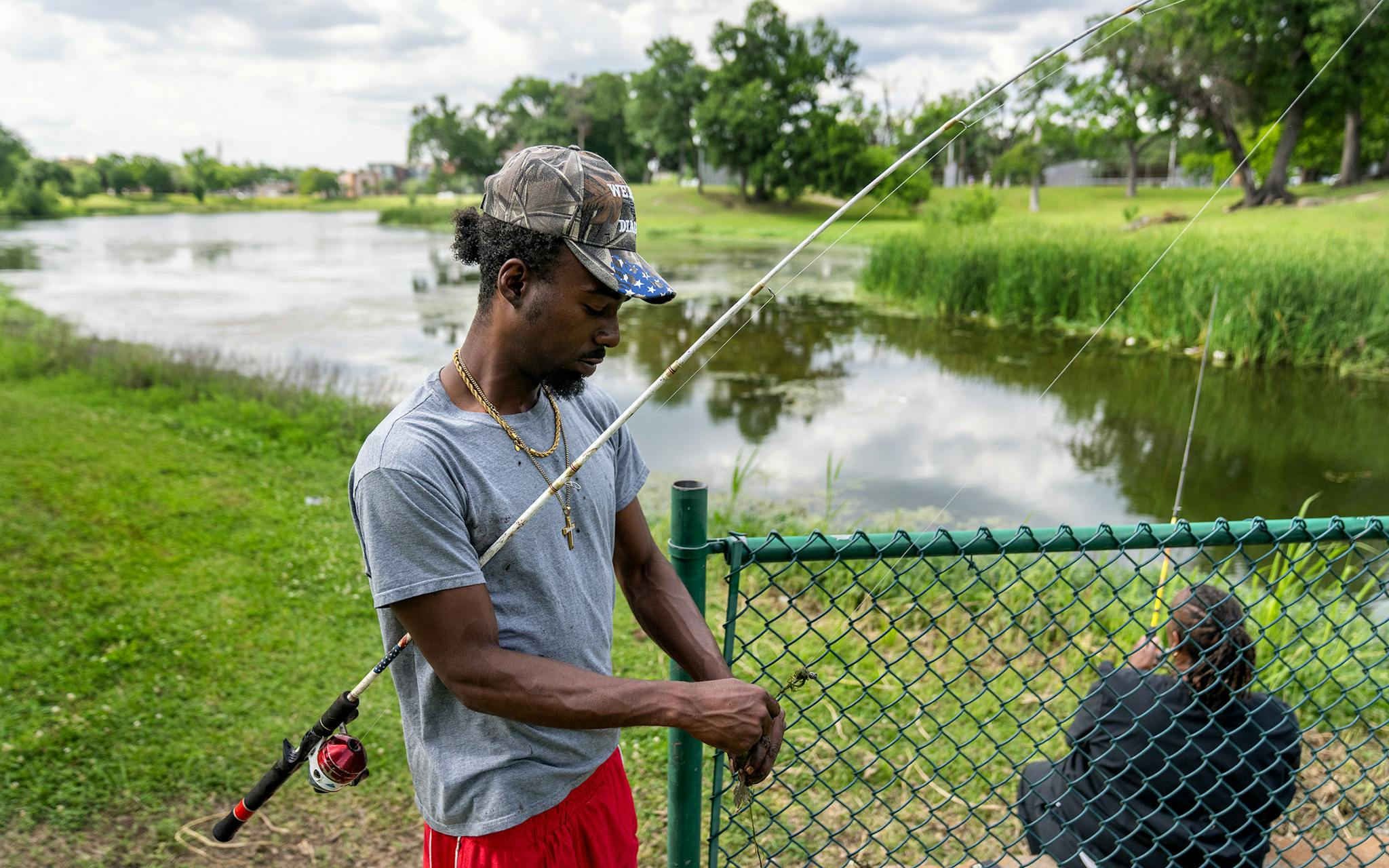 May 10 4:32 P.M. Eli Calloway, 36, removes a bluegill from his hook while fishing at Lake Cliff Park. Calloway was born and raised in Oak Cliff and attended South Oak Cliff High School, where his father taught history.