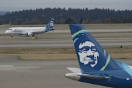 A passenger plane with SkyWest Airlines, left, a regional airline under contract with Alaska...