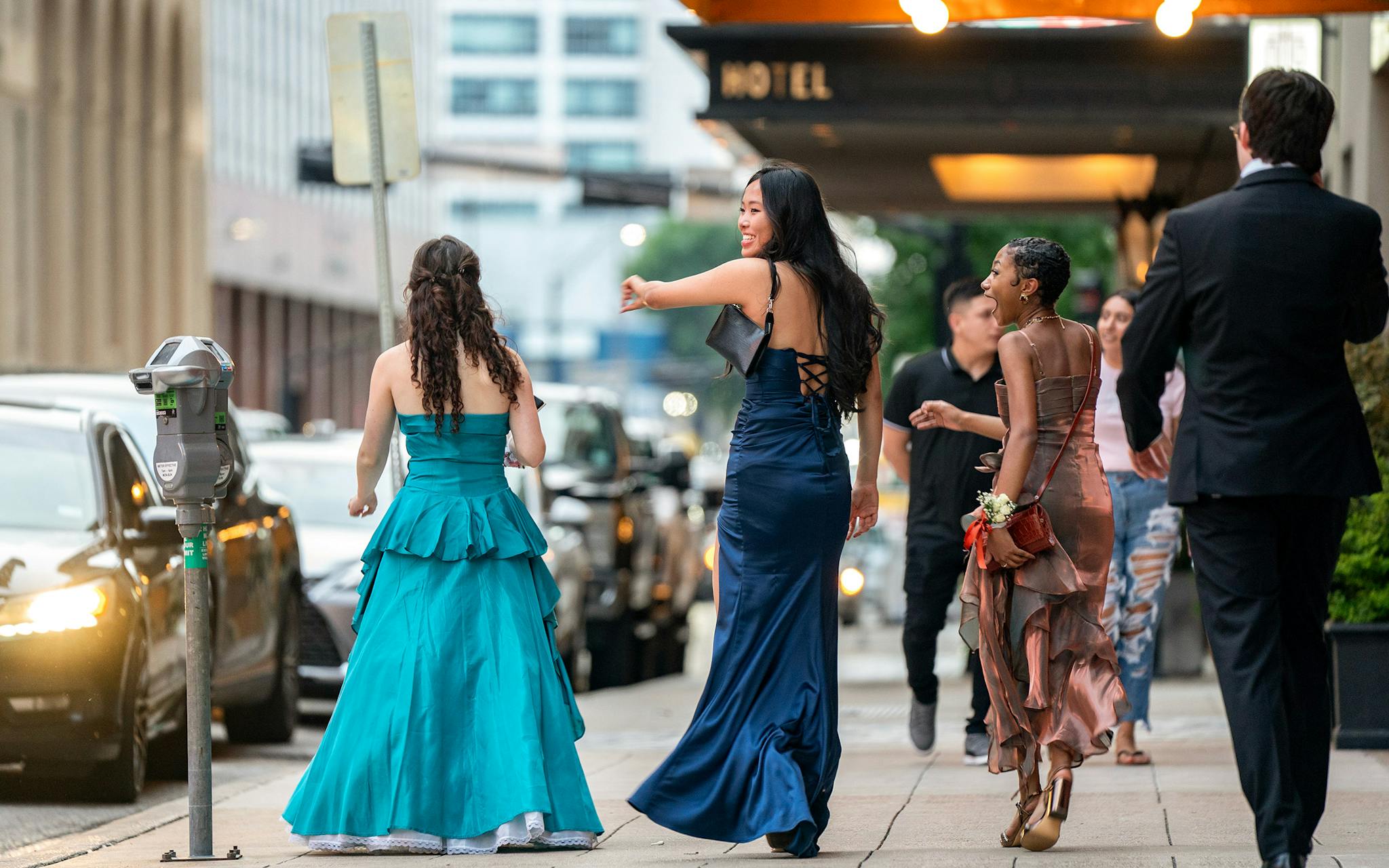 May 10 7:53 P.M. Young people dressed up for the evening walk west along Commerce Street in front of the Adolphus Hotel. It was prom night for many local high schools, and students were out in numbers taking photos in AT&T Discovery Plaza.