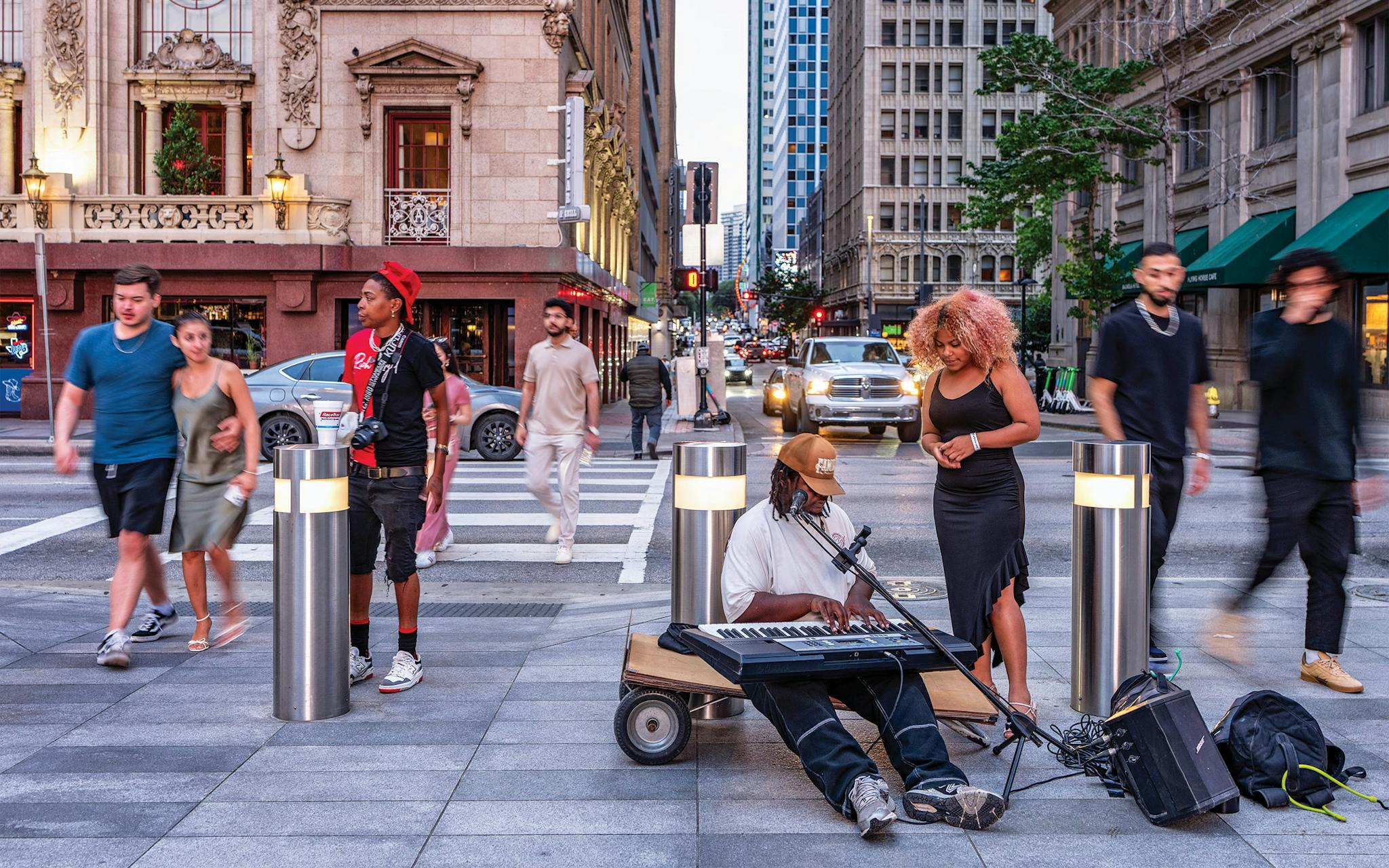 May 10 8:01 P.M. A street musician playing Christian worship songs as pedestrians cross Commerce toward the AT&T Discovery District.