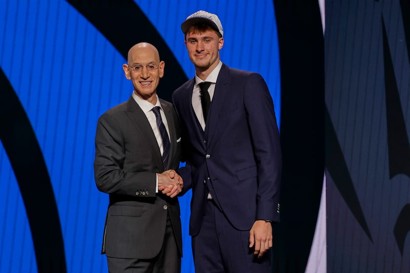 Cooper Flagg, right, poses for a photo with NBA commissioner Adam Silver after being...