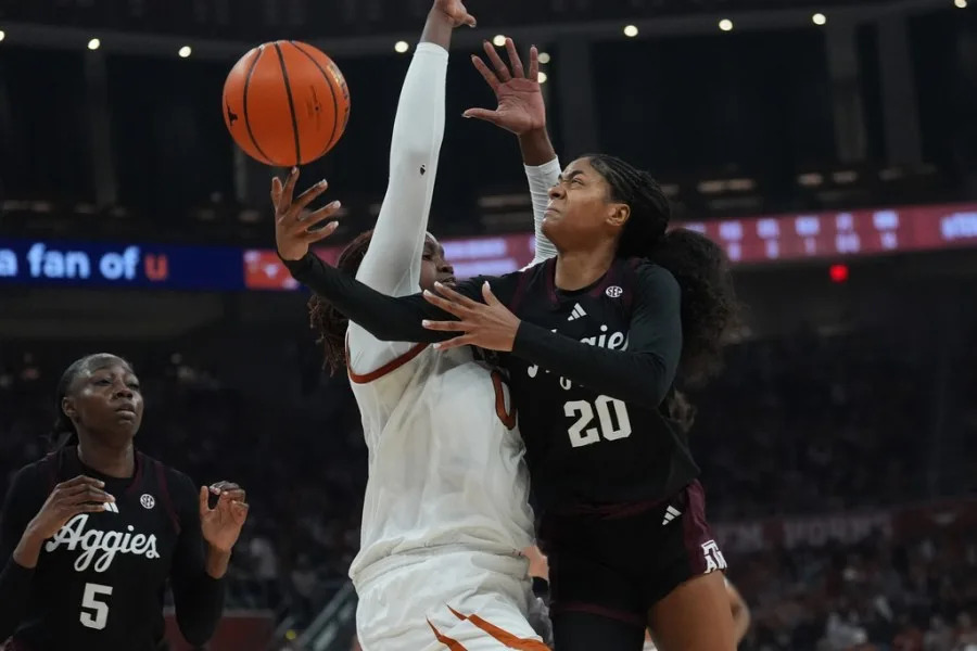 Texas A&M guard Janae Kent (20) drives to the basket against Texas center Kyla Oldacre (00) during the first half of an NCAA college basketball game in Austin, Texas, Sunday, Jan. 18, 2026. (AP Photo/Eric Gay)