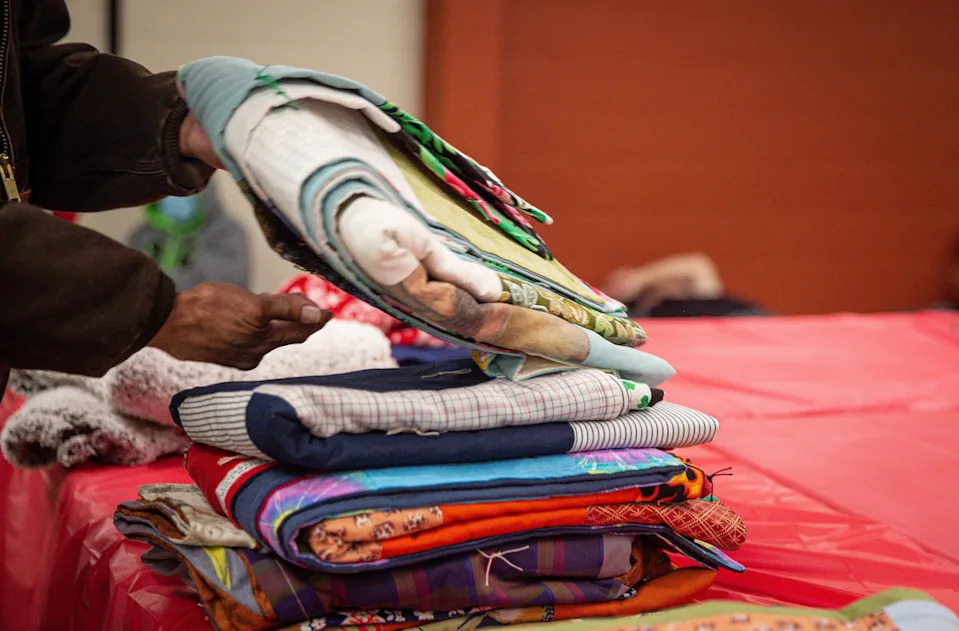 Someone seeking shelter from the winter storm picks out a blanket at the Salvation Army warming center, Jan. 20, 2022, in Corpus Christi. The shelter had 30 beds on Thursday and staff handed out food and water.