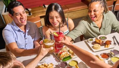 A group of diners cheers over platters of food