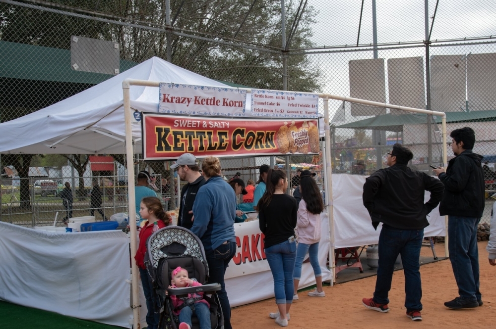 people in line at a tent selling kettle corn