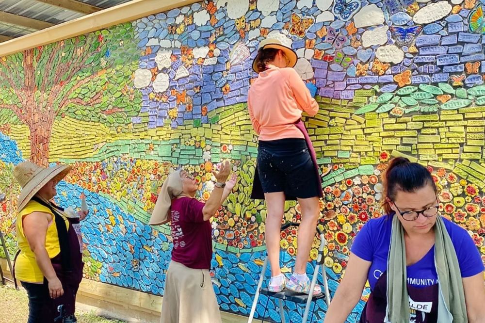 An image of several individuals painting a mural.