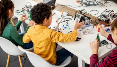 A group of kids programming electric toys and robots at robotics classroom