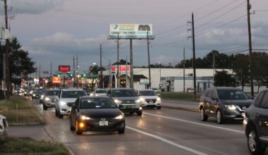Cars driving along road in Spring while sun is setting