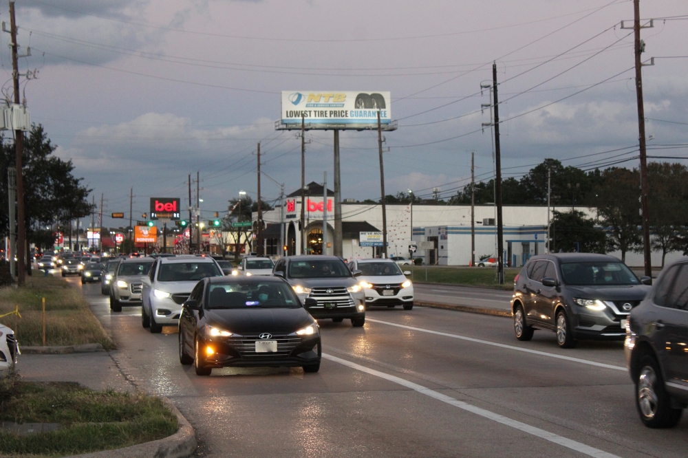 Cars driving along road in Spring while sun is setting