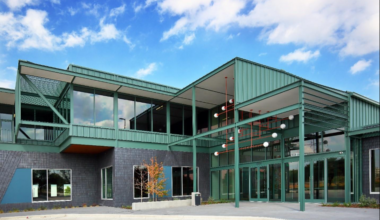 An exterior view of the green metal and gray brick offices at Assembly Park