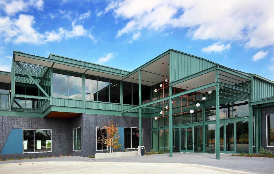 An exterior view of the green metal and gray brick offices at Assembly Park
