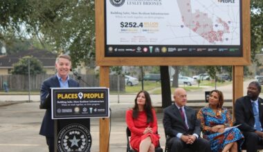A man speaks at a podium with government officials