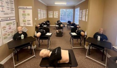 CPR dummies on tables in a classroom setting.