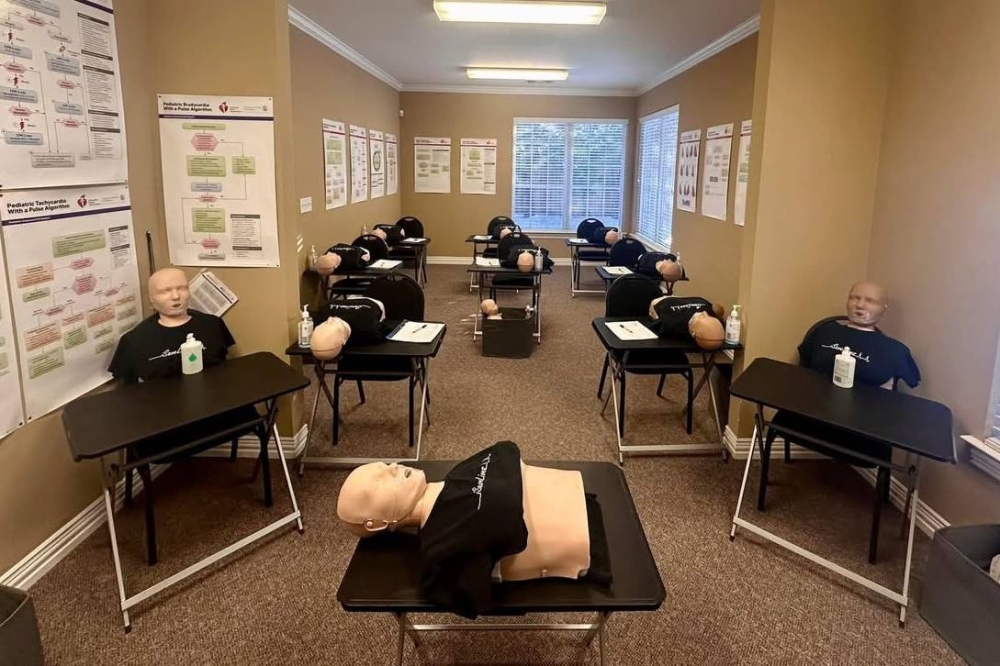 CPR dummies on tables in a classroom setting.