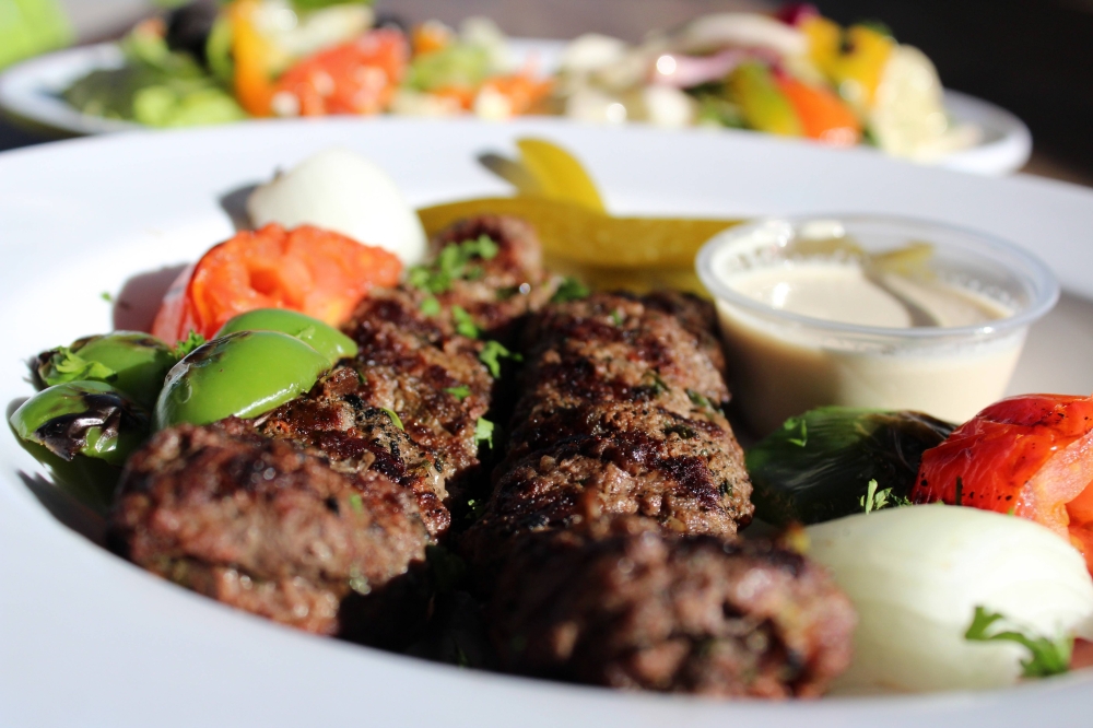 a plate with beef kabobs and fresh vegetables