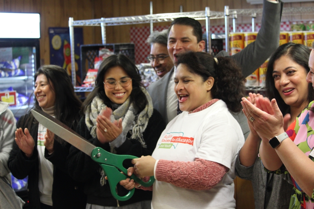 People cut a ribbon and clap their hands