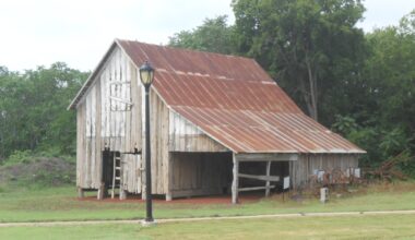 an old barn in a patch of grass