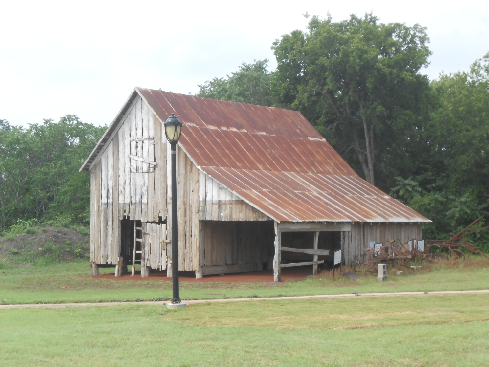 an old barn in a patch of grass