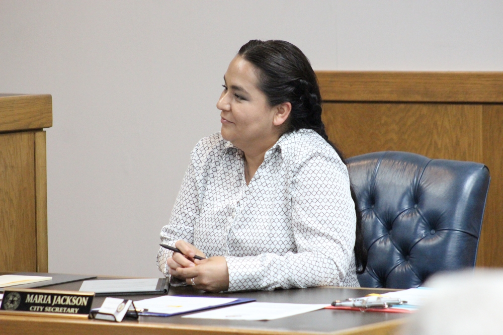 Maria Jackson sitting at her desk during a May city council meet