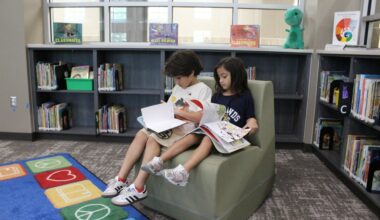 Third grader Christopher Garcia and first grader Gianna Garcia, siblings, enjoy their favorite books in the library at New Caney ISD's Highlands Elementary School. (Emily Lincke/Community Impact)