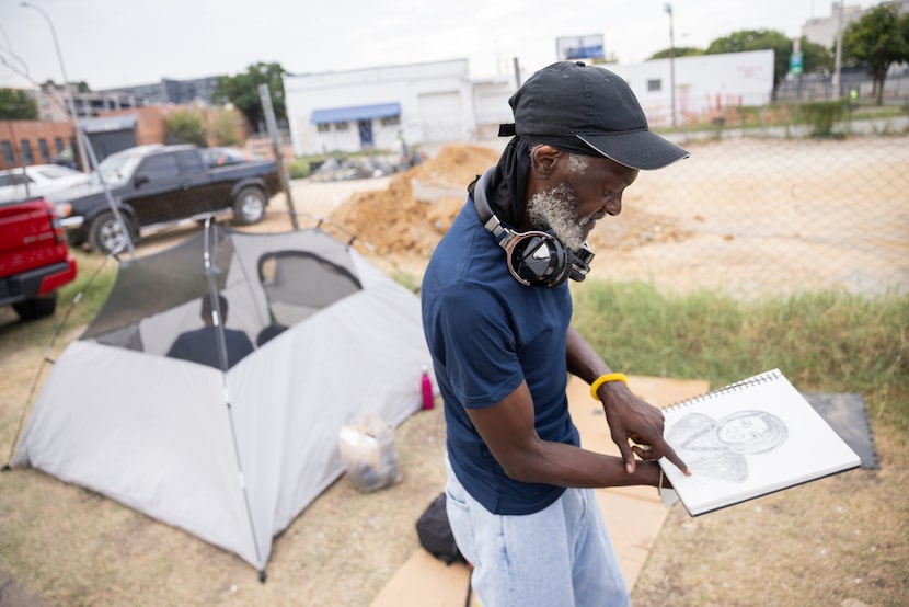 Booker Campbell looks at his sketches as he talks to Hannah Sims (not pictured), a trained...