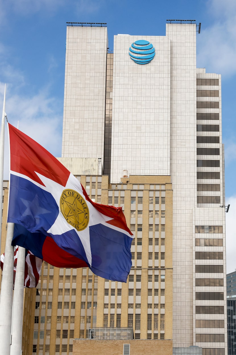 A City of Dallas flag flies in front of AT&T headquarters building Whitacre Tower pictured...