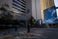 Pedestrians walk through AT&T Discovery District past the communications company’s...