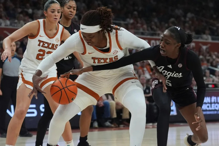 Texas center Kyla Oldacre, left, and Texas A&M forward Vanessa Saidu (5) scramble for the ball during the first half of an NCAA college basketball game in Austin, Texas, Sunday, Jan. 18, 2026. (AP Photo/Eric Gay)