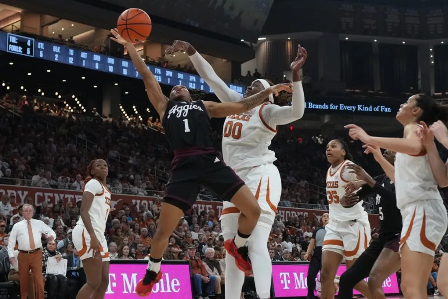 Texas A&M guard Ny’ceara Pryor (1) is blocked as she drives to the basket against Texas center Kyla Oldacre (00) during the first half of an NCAA college basketball game in Austin, Texas, Sunday, Jan. 18, 2026. (AP Photo/Eric Gay)