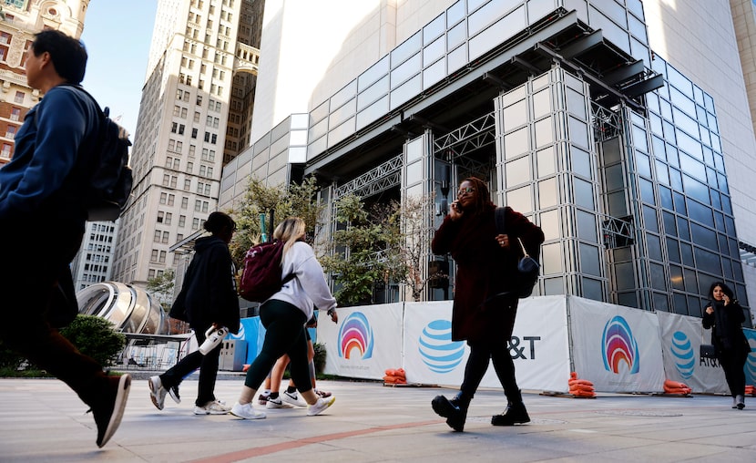 Employees and visitors of AT&T leave their offices at the end of the day, passing through...