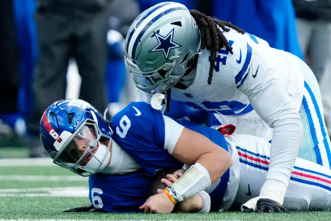 New York Giants quarterback Jaxson Dart (6) is tackled by Dallas Cowboys defensive end Jadeveon Clowney (42), Sunday, January 4, 2026, in East Rutherford.