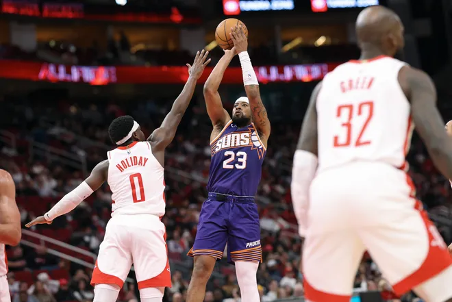 Dec 5, 2025; Houston, Texas, USA; Phoenix Suns guard Jordan Goodwin (23) shoots the ball as Houston Rockets guard Aaron Holiday (0) defends during the fourth quarter at Toyota Center. Mandatory Credit: Troy Taormina-Imagn Images