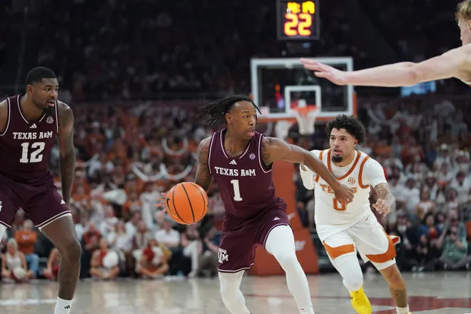 Jan 17, 2026; Austin, Texas, USA; Texas A&M Aggies guard Josh Holloway (1) dribbles past Texas Longhorns guard Jordan Pope (0) during the first half at Moody Center. Mandatory Credit: Dustin Safranek-Imagn Images