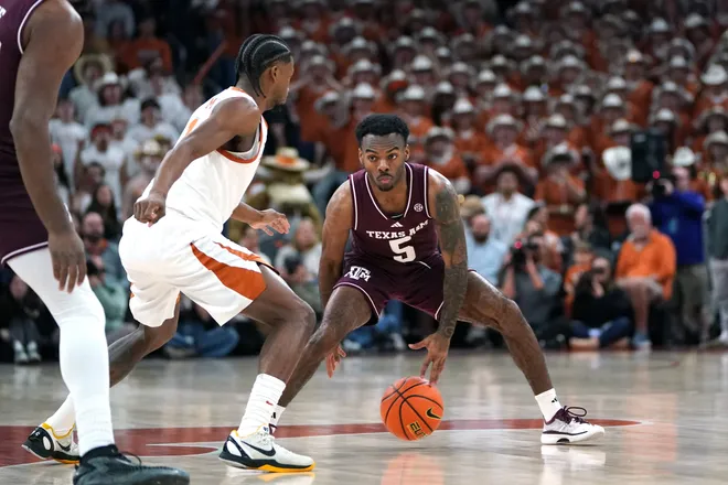 Jan 17, 2026; Austin, Texas, USA; Texas A&M Aggies guard Jacari Lane (5) dribbles against Texas Longhorns guard Tramon Mark (12) during the first half at Moody Center. Mandatory Credit: Dustin Safranek-Imagn Images