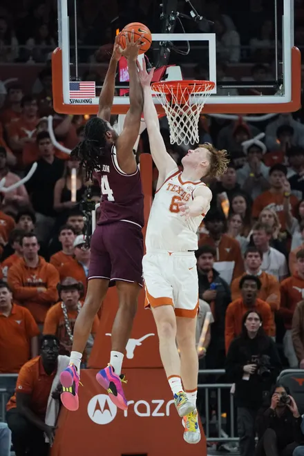 Jan 17, 2026; Austin, Texas, USA; Texas A&M Aggies forward Jamie Vinson (4) dunks against Texas Longhorns center Matas Vokietaitis (8) during the second half at Moody Center. Mandatory Credit: Dustin Safranek-Imagn Images