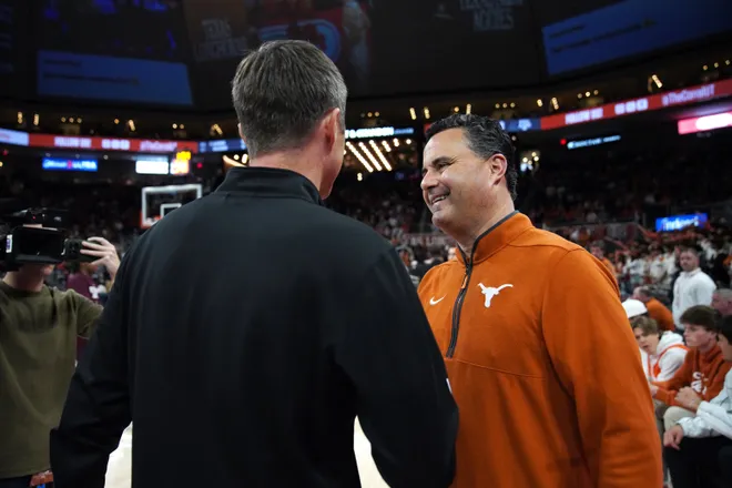 Jan 17, 2026; Austin, Texas, USA; Texas Longhorns head coach Sean Miller meets with Texas A&M Aggies head coach Bucky McMillan before the game at Moody Center. Mandatory Credit: Dustin Safranek-Imagn Images