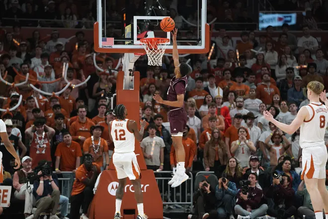 Jan 17, 2026; Austin, Texas, USA; Texas A&M Aggies guard Ryan Griffen (3) makes a lay up past Texas Longhorns guard Tramon Mark (12) during the second half at Moody Center. Texas Longhorns center Matas Vokietaitis (8) reacts. Mandatory Credit: Dustin Safranek-Imagn Images