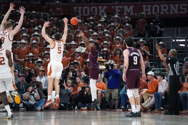 Jan 17, 2026; Austin, Texas, USA; Texas A&M Aggies guard Marcus Hill (0) shoots a three point basket against Texas Longhorns forward Camden Heide (5) during the second half at Moody Center. Mandatory Credit: Dustin Safranek-Imagn Images