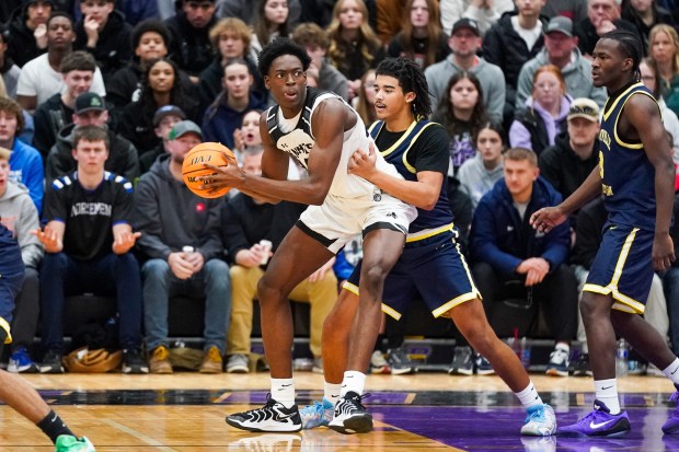 Kaneland's Jeffrey Hassan (34) plays the ball in the post against Yorkville Christian's Kayden Maxwell (2) during a Plano Christmas Classic Final game in Plano on Tuesday, Dec. 30, 2025. (Sean King / For The Beacon-News)