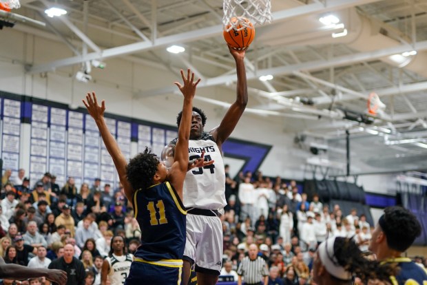Kaneland's Jeffrey Hassan (34) shoots the ball from the post over Yorkville Christian's Carter Wells (11) during a Plano Christmas Classic Final game in Plano on Tuesday, Dec. 30, 2025. (Sean King / For The Beacon-News)