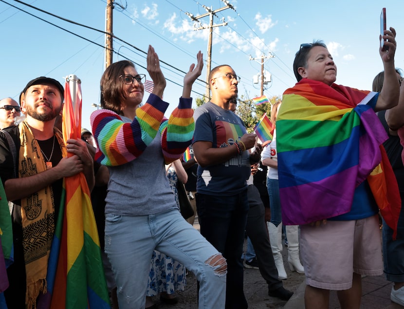 Rainbow Crosswalk supporters respond to the message of a guest speaker during a meeting to...