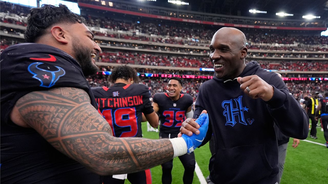 Houston Texans defensive tackle Tommy Togiai, left, celebrates his touchdown against the Indianapolis Colts with head coach Demeco Ryans, right, during the second half of an NFL football game in Houston, Sunday, Jan. 4, 2026. (AP Photo/Ashley Landis)