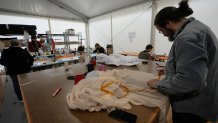 Tailors work on clothes during rehearsals for the opening ceremony of the Milan Cortina 2026 Winter Olympic Games, at a compound in a big tent next to San Siro Stadium, in Milan, Italy, Saturday, Jan. 24, 2026.