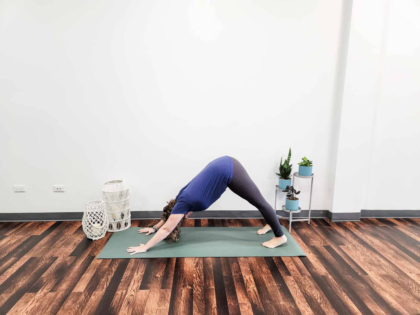 Downward Dog: Starting on your hands and knees, curl your toes under
and lift your hips up and back. Press through your hands and reach through
your tailbone. Don't worry about getting your heels to touch the mat.