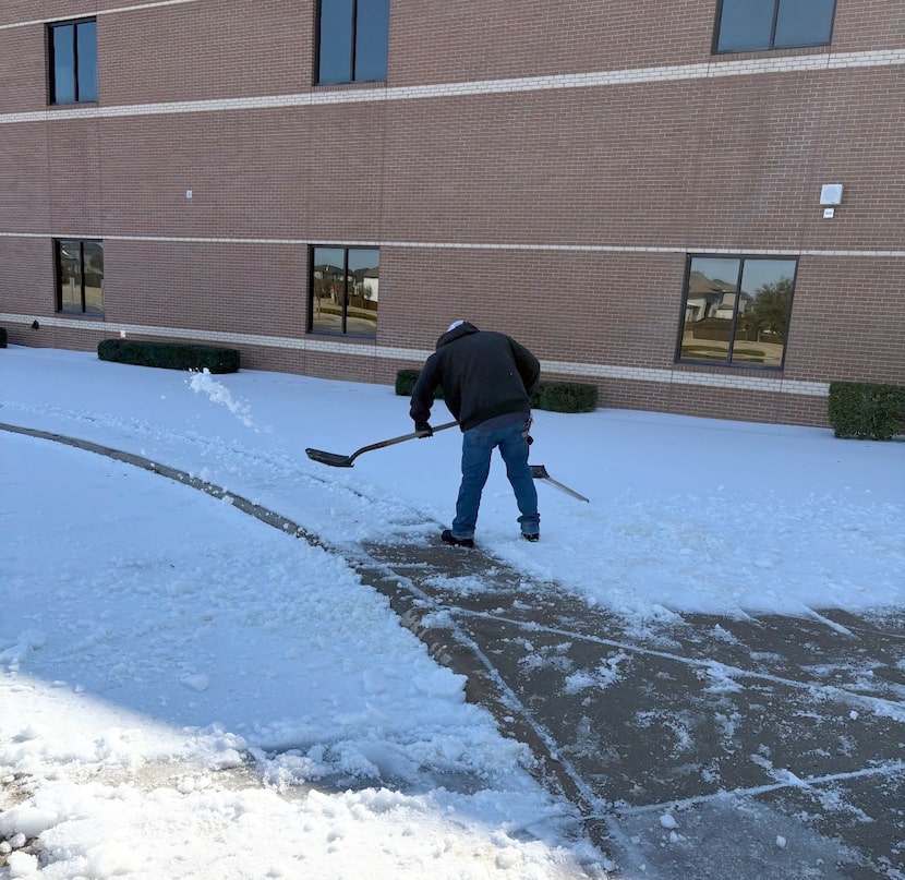 A maintenance worker clears snow near Preston Elementary school in Allen ISD.